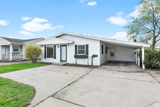 view of front of property with concrete driveway and an attached carport