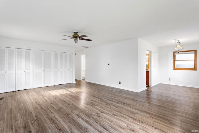 unfurnished living room with baseboards, ceiling fan, visible vents, and wood finished floors