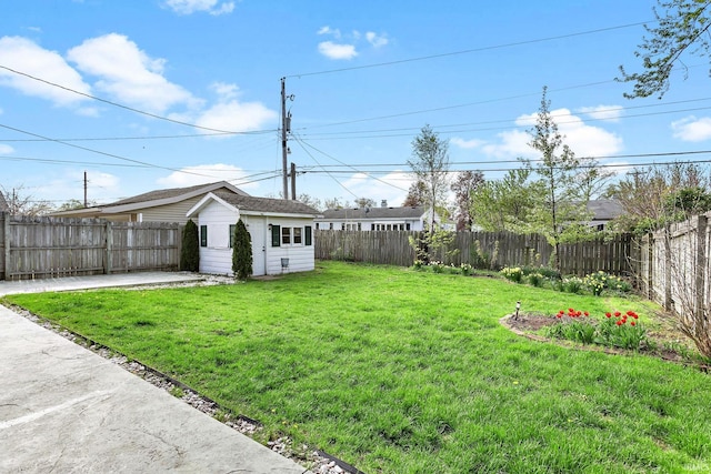 view of yard with a patio, a fenced backyard, and an outbuilding