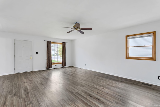 unfurnished room with ceiling fan, dark wood-style floors, and baseboards
