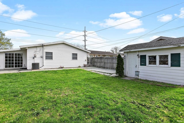 view of yard featuring a patio, central AC, and fence