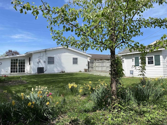 rear view of property featuring central AC, a yard, and fence