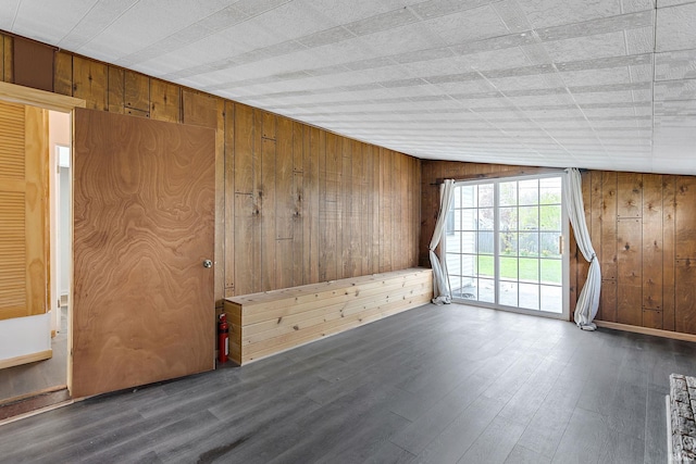 unfurnished room with wood walls and wood finished floors