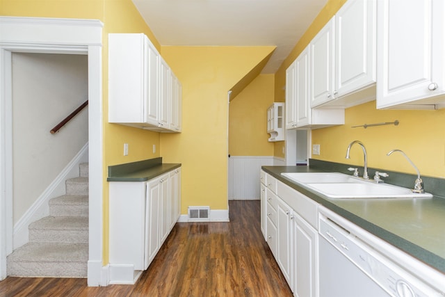 kitchen featuring dark wood-style flooring, dark countertops, white dishwasher, white cabinetry, and a sink