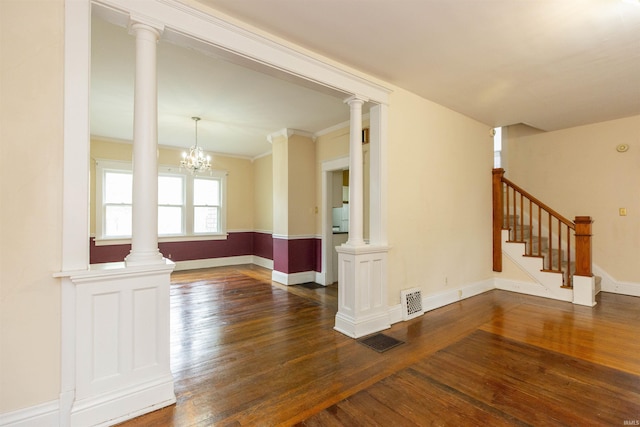 spare room featuring baseboards, dark wood-style floors, a chandelier, and visible vents