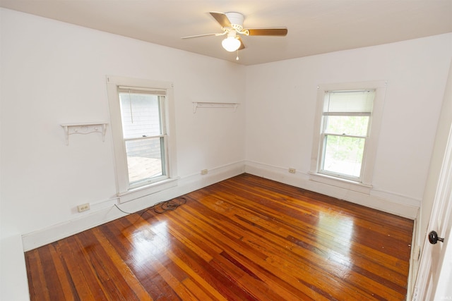 empty room featuring a ceiling fan, a wealth of natural light, and hardwood / wood-style floors