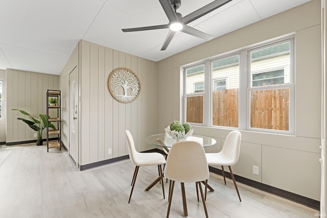 dining space with baseboards, a ceiling fan, and light wood-style flooring