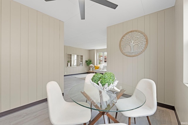 dining room with baseboards, a ceiling fan, and wood finished floors