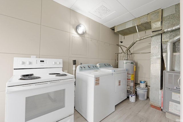 clothes washing area with gas water heater, light wood-style flooring, laundry area, and washing machine and clothes dryer