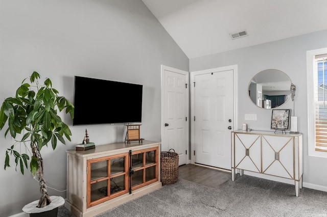 carpeted living room featuring baseboards, visible vents, and high vaulted ceiling