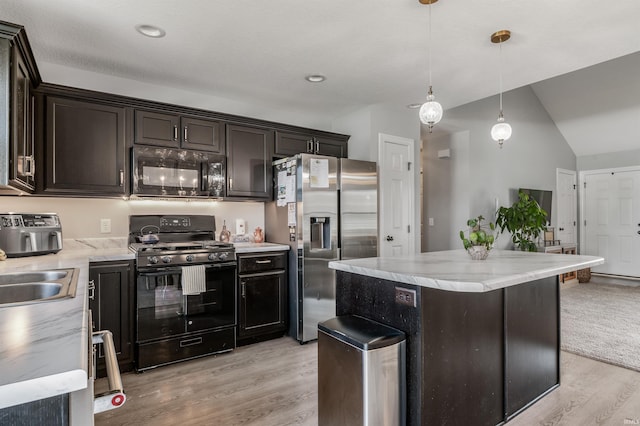 kitchen featuring a sink, a center island, lofted ceiling, light wood-type flooring, and black appliances
