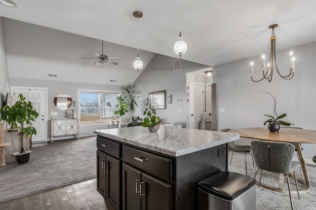 kitchen featuring visible vents, light wood-type flooring, light countertops, ceiling fan with notable chandelier, and vaulted ceiling