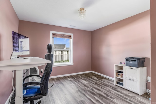 home office featuring baseboards, visible vents, and wood finished floors