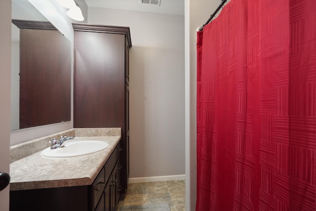 202 Jeremy Dr, Milford, IN 46542 - bathroom with vanity, baseboards, stone finish flooring, curtained shower, and visible vents