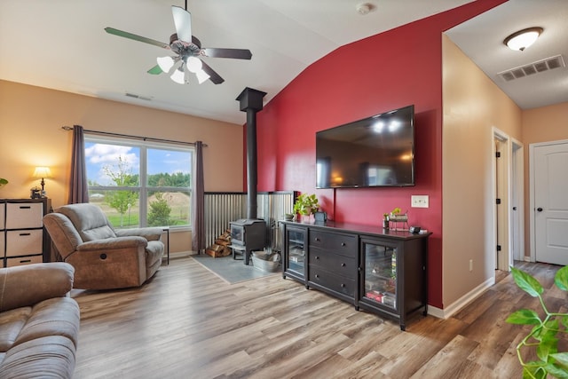 202 Jeremy Dr, Milford, IN 46542 - living area featuring visible vents, a wood stove, lofted ceiling, and wood finished floors