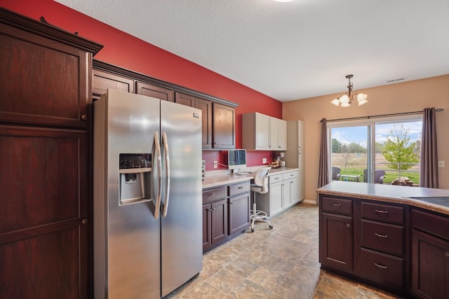 202 Jeremy Dr, Milford, IN 46542 - kitchen featuring hanging light fixtures, light countertops, built in study area, a notable chandelier, and stainless steel fridge