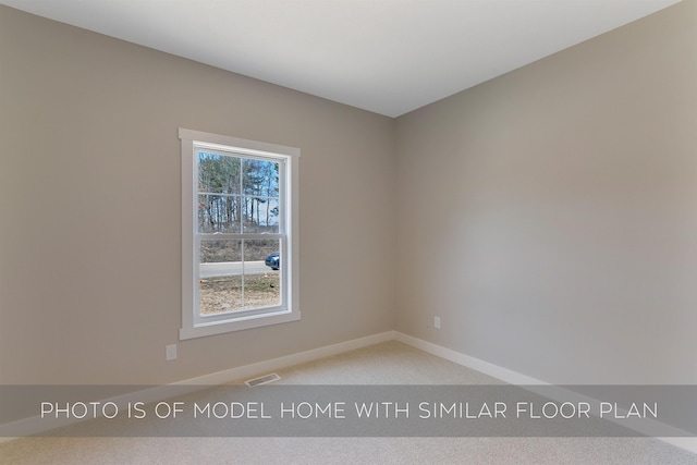 empty room with baseboards, visible vents, and light carpet