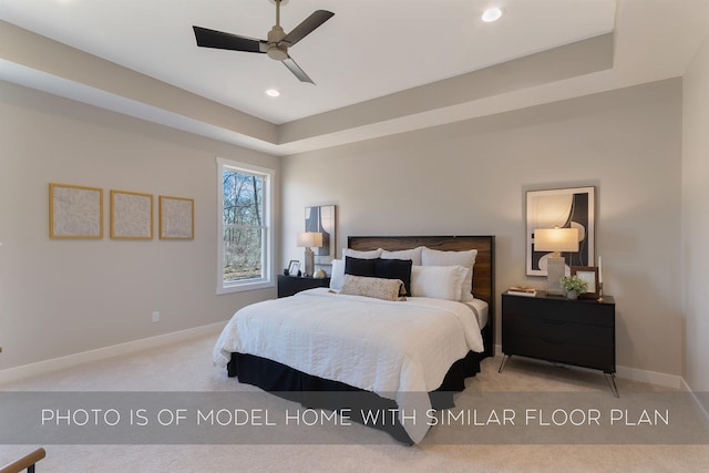 bedroom featuring a raised ceiling, carpet floors, recessed lighting, baseboards, and a ceiling fan