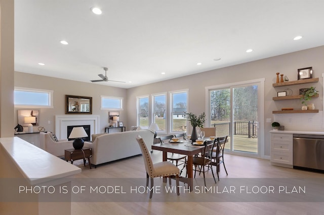 dining room with recessed lighting, ceiling fan, light wood-type flooring, and a fireplace