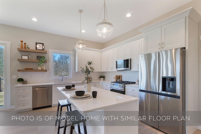 kitchen with a healthy amount of sunlight, appliances with stainless steel finishes, decorative backsplash, and a sink