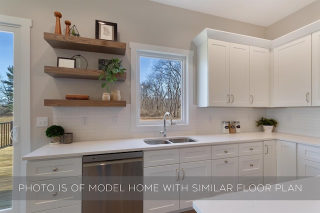 kitchen with stainless steel dishwasher, a sink, white cabinetry, and tasteful backsplash