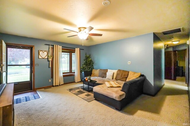 living area with visible vents, a ceiling fan, baseboards, and carpet