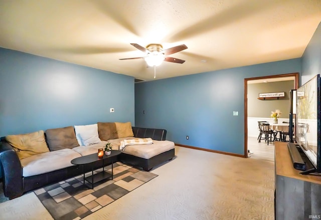 living room with baseboards, carpet, and a ceiling fan
