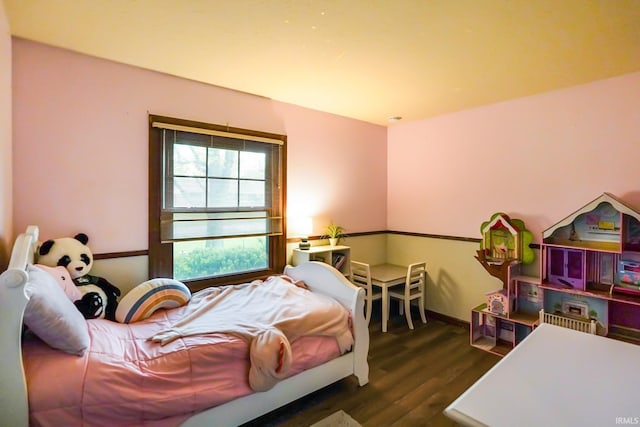 bedroom with baseboards and wood finished floors