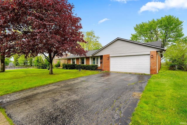 view of front of house featuring brick siding, a garage, a front lawn, and driveway