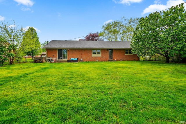 back of house featuring a yard and brick siding