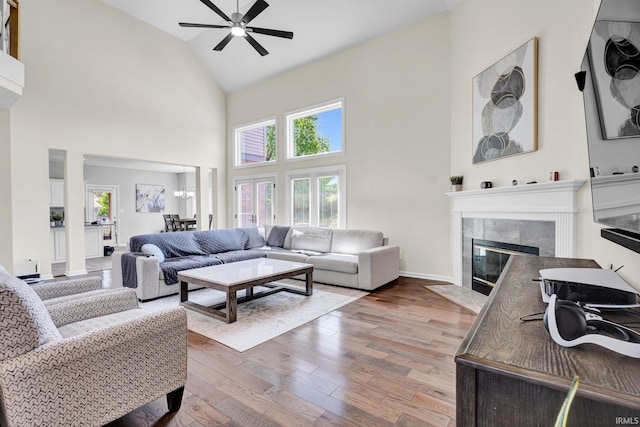7911 N Thames Dr, Bloomington, IN 47408 - living area featuring a ceiling fan, wood finished floors, high vaulted ceiling, baseboards, and a premium fireplace