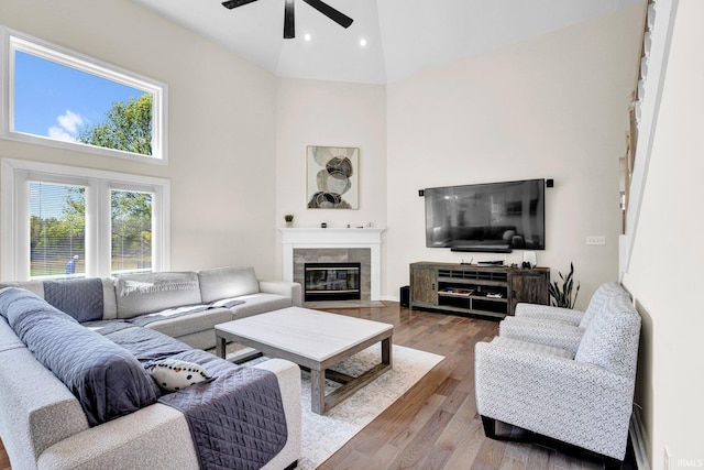 7911 N Thames Dr, Bloomington, IN 47408 - living area featuring ceiling fan, high vaulted ceiling, a tiled fireplace, recessed lighting, and wood finished floors
