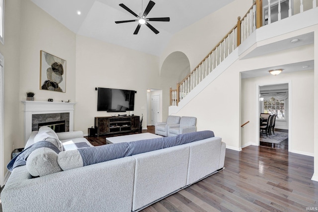 7911 N Thames Dr, Bloomington, IN 47408 - living area featuring ceiling fan, high vaulted ceiling, stairs, wood finished floors, and a high end fireplace