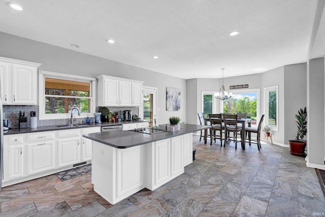 7911 N Thames Dr, Bloomington, IN 47408 - kitchen with dark countertops, a sink, a chandelier, tasteful backsplash, and stone tile flooring