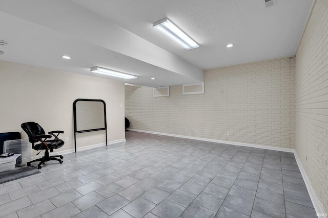 7911 N Thames Dr, Bloomington, IN 47408 - finished below grade area featuring baseboards, recessed lighting, and brick wall