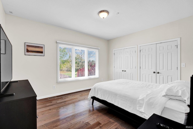 7911 N Thames Dr, Bloomington, IN 47408 - bedroom with wood finished floors, baseboards, two closets, and visible vents
