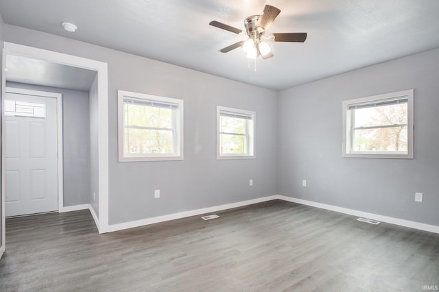 spare room featuring a healthy amount of sunlight and baseboards
