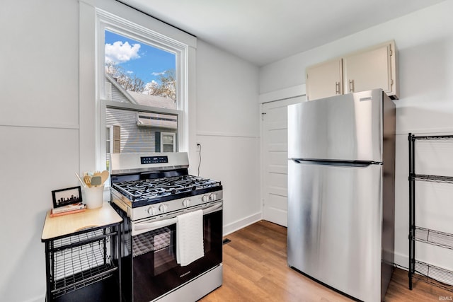 kitchen featuring baseboards, light wood-style flooring, and stainless steel appliances