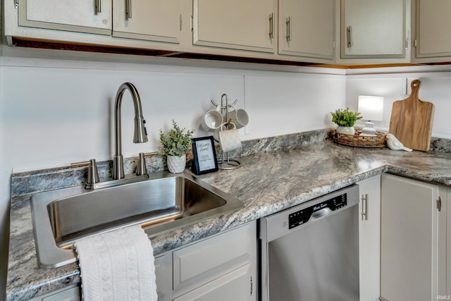 kitchen with light countertops, a sink, and dishwasher