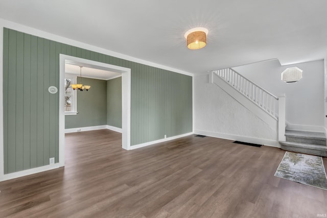 unfurnished living room with baseboards, stairs, and wood finished floors