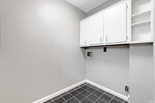 washroom featuring baseboards, hookup for a washing machine, cabinet space, and dark tile patterned flooring