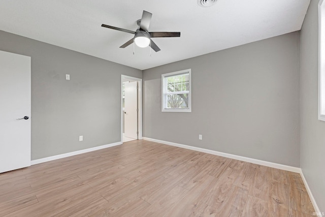 unfurnished room featuring baseboards, light wood-style flooring, ceiling fan, and visible vents