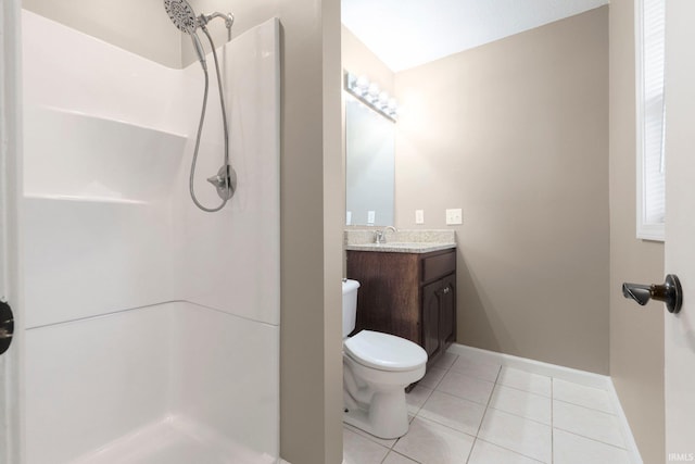 bathroom with a stall shower, vanity, tile patterned floors, baseboards, and toilet