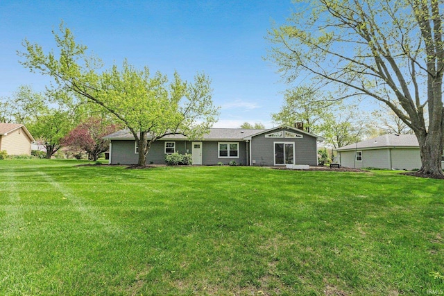 rear view of house with a lawn and a chimney