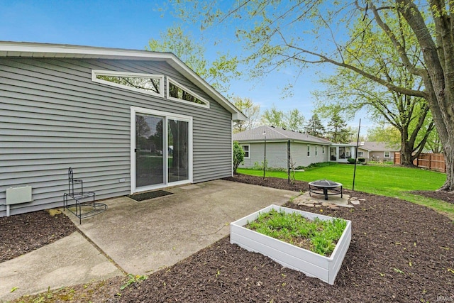 back of property featuring a lawn, a fire pit, and a patio