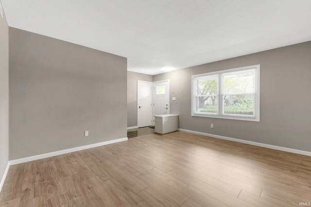 spare room featuring light wood-style floors and baseboards