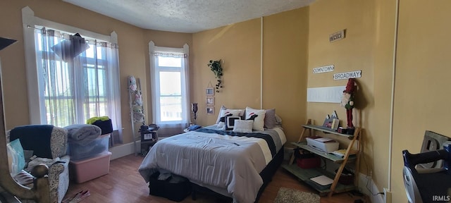 bedroom featuring a textured ceiling and wood finished floors