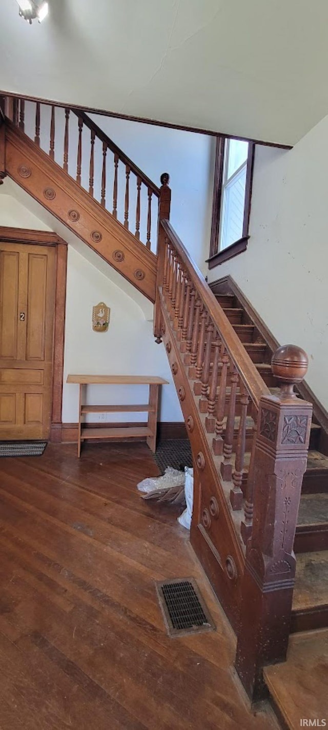 stairs featuring baseboards, visible vents, and hardwood / wood-style floors