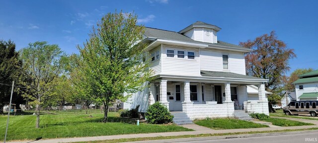 traditional style home with covered porch and a front yard