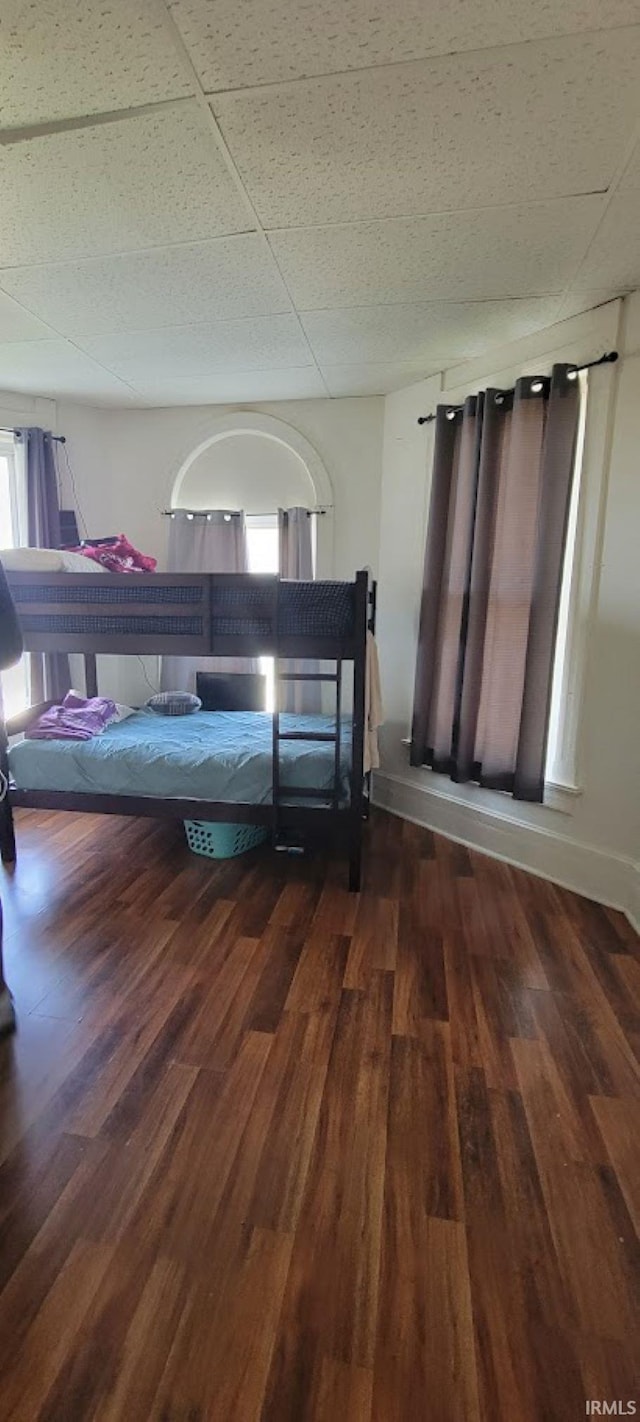 bedroom with wood finished floors and multiple windows